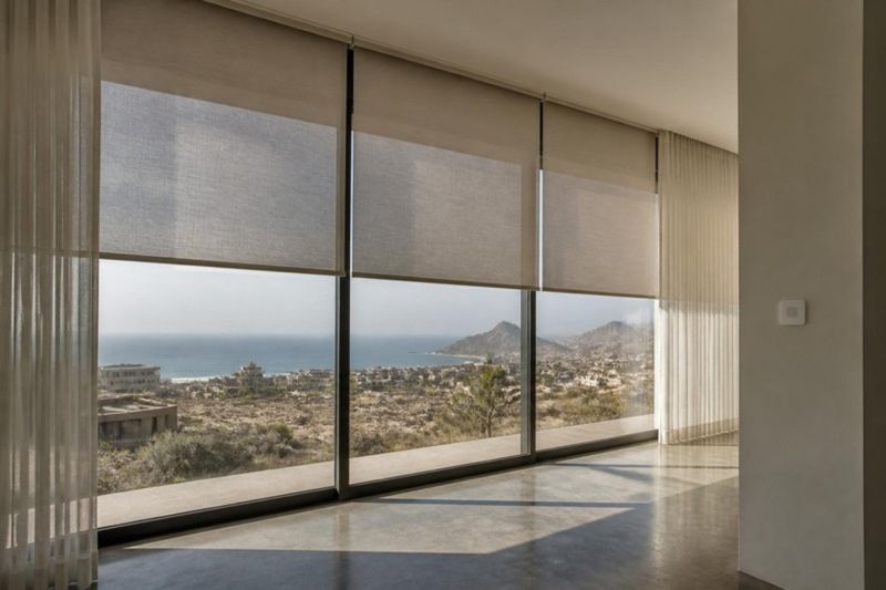 Persianas motorizadas en ventanal de villa con vista al mar